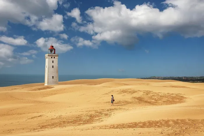 Framed Print : Woman walks on sand dunes in front of the lighthouse of Rubjerg Knude, Hjorring municipality, north Jutland region, Jutland, north of Denmark, Denmark, Europe Framed Print : Woman walks on sand dunes in front of the lighthouse of Rubjerg Knude, Hjorring municipality, north Jutland region, Jutland, north of Denmark, Denmark, Europe