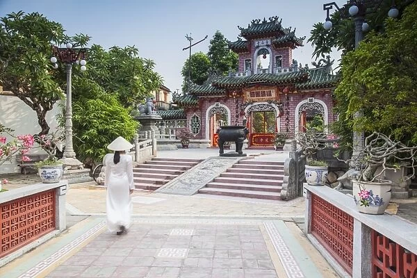 Woman wearing Ao Dai dress at Phouc Kien Assembly Hall, Hoi An (UNESCO World Heritage Site)