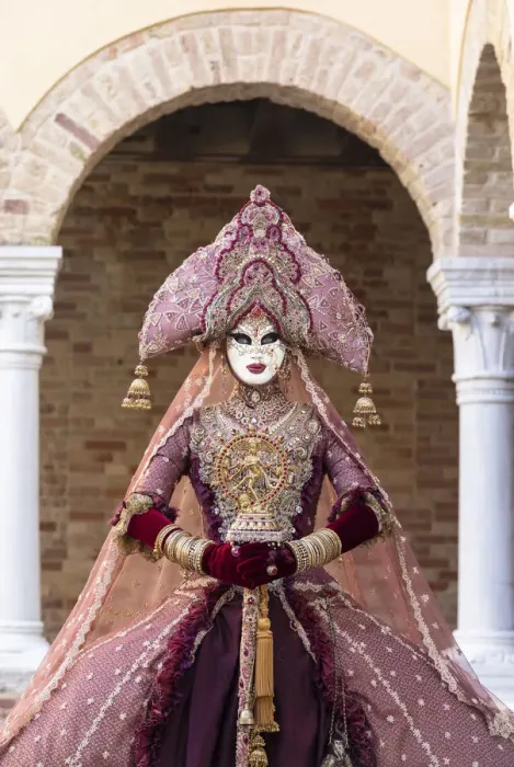 Framed Print : A woman wearing an Indian style costume and mask poses in the cloisters of Chiesa di San Framed Print : A woman wearing an Indian style costume and mask poses in the cloisters of Chiesa di San