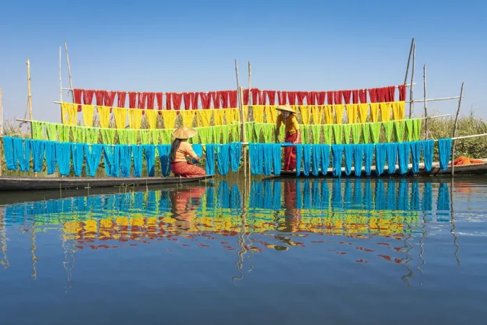 Framed Print : Two women hanging dyed yarn from boats to dry in a traditional weaving village on Lake Framed Print : Two women hanging dyed yarn from boats to dry in a traditional weaving village on Lake