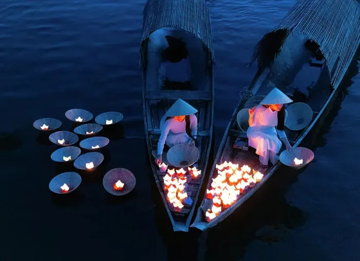 Framed Print : Women laying floating lanterns on the Perfume River at dusk, Hue, Central Vietnam