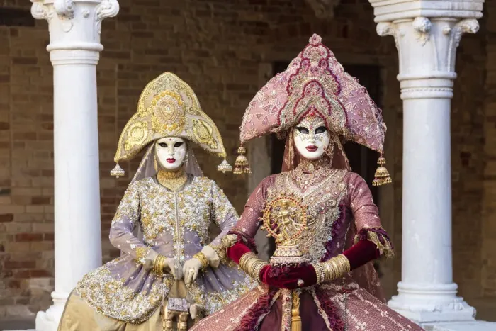 Framed Print : Two women wearing Indian style costumes and masks pose in the cloisters of Chiesa di San Framed Print : Two women wearing Indian style costumes and masks pose in the cloisters of Chiesa di San