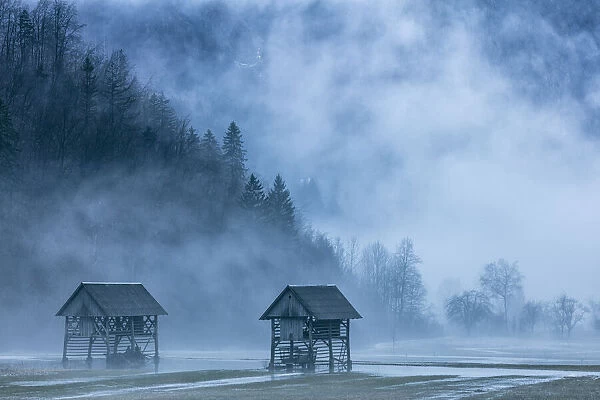 Wooden barns in Mist near Lake Bohinj, Slovenia