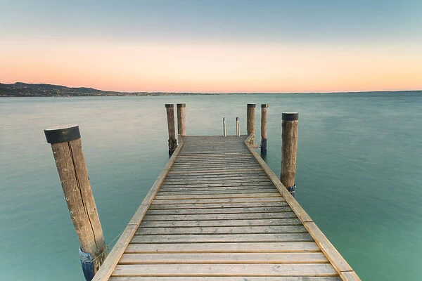 The wooden pier of Punta San Vigilio on the eastern shore of Lake Garda at sunset