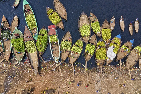 Workers unload watermelons from the boats using big baskets, Sadarghat, Dhaka, Bangladesh