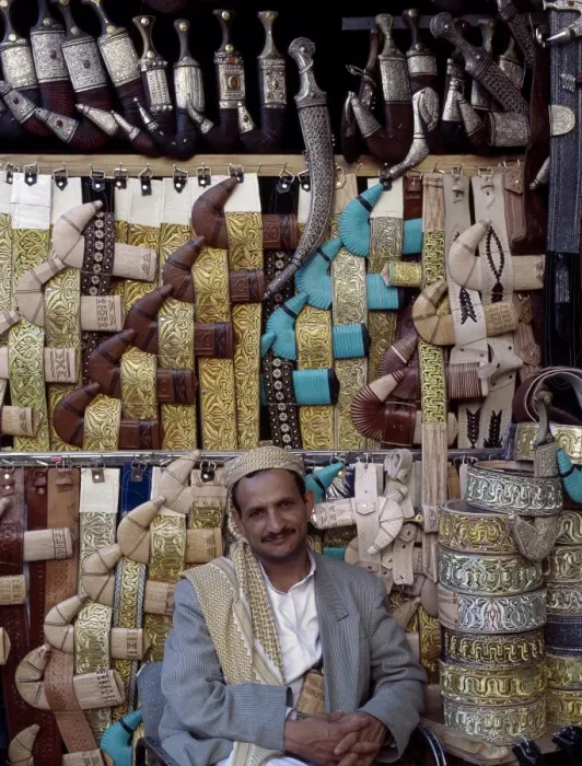 Framed Print : Yemeni trader sells traditional daggers at his stall
