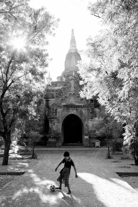 Framed Print : Young boy playing football outside an anciuent temple, Bagan, Myanmar Framed Print : Young boy playing football outside an anciuent temple, Bagan, Myanmar