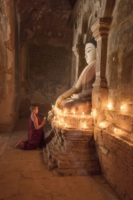Framed Print : Young Buddhist monk prays in front of a statue of Buddha in a temple in Bagan, Myanmar Framed Print : Young Buddhist monk prays in front of a statue of Buddha in a temple in Bagan, Myanmar