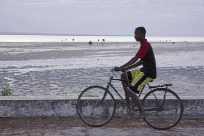 Framed Print : A young man cycling along the sea wall on Ibo Island Framed Print : A young man cycling along the sea wall on Ibo Island