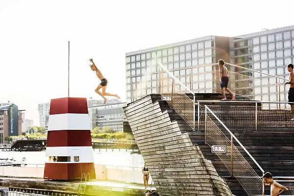 Young people diving into a swimming pool in a water canal in Copenhagen, Denmark