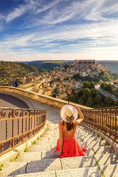 Young woman admiring the enchanting hilltop city of Ragusa Ibla from the stairs of Santa