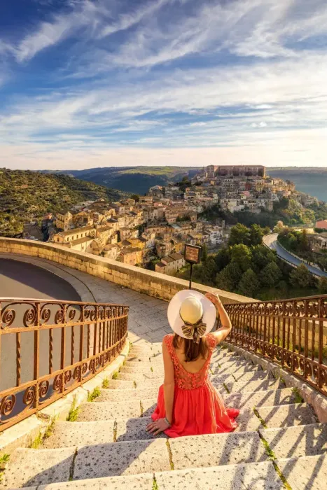 Framed Print : Young woman admiring the enchanting hilltop city of Ragusa Ibla from the stairs of Santa Framed Print : Young woman admiring the enchanting hilltop city of Ragusa Ibla from the stairs of Santa