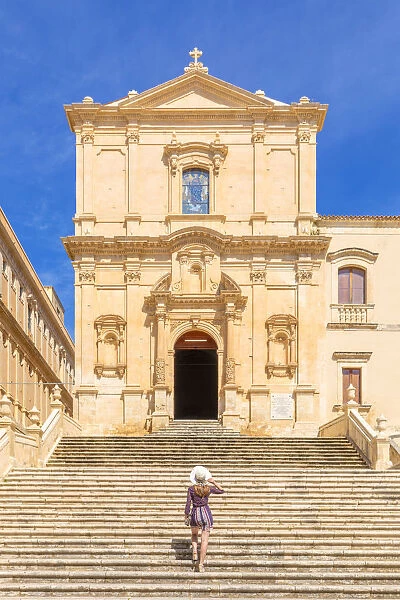 Young woman climbing the stairs of San Francesco all Immacolata church, Noto