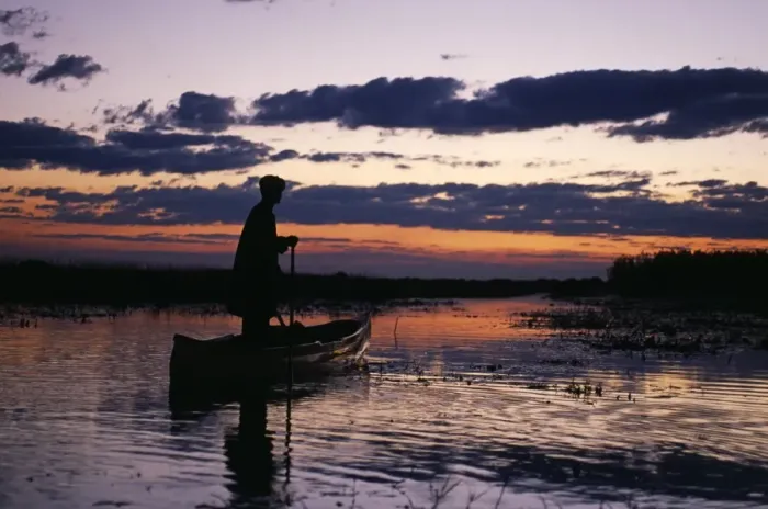 Framed Print : Zambia Game scout poling mokorro along Lukulu River at sunset