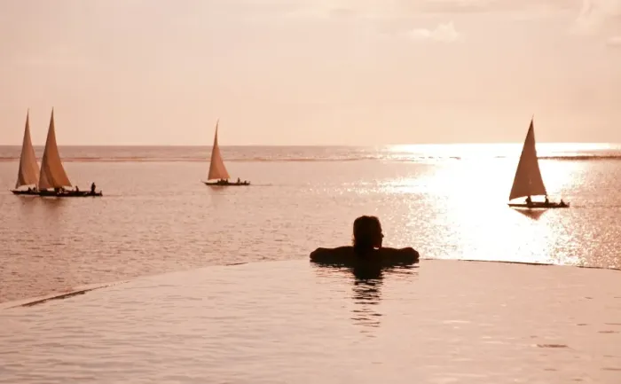 Framed Print : Zanzibar, Matemwe Bungalows. A tourist stands at the edge of an infinity pool watching the Dhows Framed Print : Zanzibar, Matemwe Bungalows. A tourist stands at the edge of an infinity pool watching the Dhows