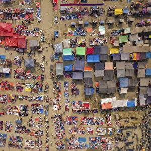 Aerial view of people trading at weekly market, seeking out products in the city of