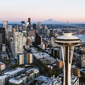 Aerial view of The Space Needle and downtown skyline at sunset with Mt Rainier in the background