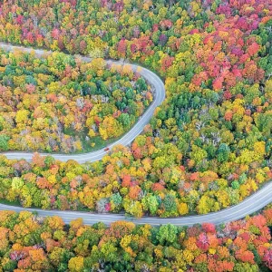 Aerial view of twisting road with vehicle in autumn, Schuss Pass, Waitsfield, Vermont, USA Aerial view of twisting road with vehicle in autumn, Schuss Pass, Waitsfield, Vermont, USA
