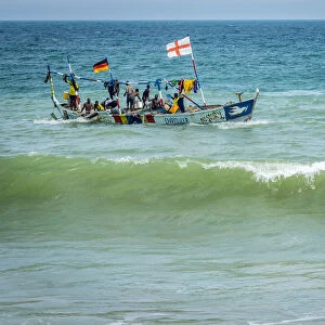 Africa, Benin, Grand Popo. A colorful fishing boat coming back home