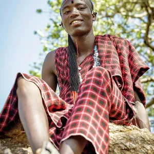 africa, Tanzania, Manyara Region. A handsome maasai warrior sitting on a rock africa, Tanzania, Manyara Region. A handsome maasai warrior sitting on a rock