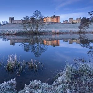 Alnwick Castle reflected in the River Aln on a frosty winter morning, Northumberland, England