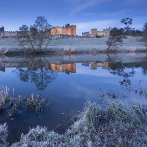 Alnwick Castle reflected in the River Aln on a frosty winter morning, Northumberland, England