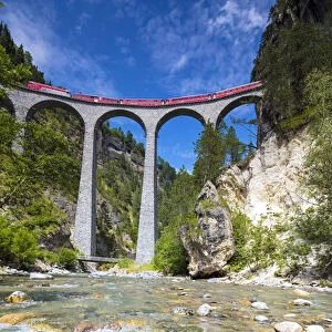 The alpine stream frames the Bernina Express train on Landwasser Viadukt Filisur Albula