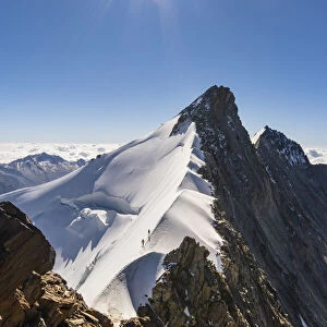 ALpinists along Nadelgrat snow ridge over 4000 meters of altitude to Nadelhorn peak