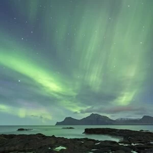 Aurora Borealis above the island of Kalsoy, photographed from the coastline of Gjogv