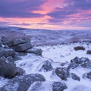 Beautiful sunrise over a frozen and snow covered Belstone Tor, Dartmoor National Park