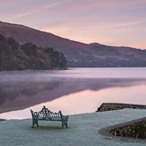 Bench on Ullswater at dawn on a frosty winter morning, Lake District, Cumbria, England