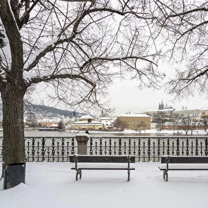 Empty benches facing view of Prague Castle in winter, Prague, Bohemia, Czech Republic
