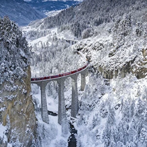 Bernina Express train on Landwasser viaduct in a snowy winter, Filisur