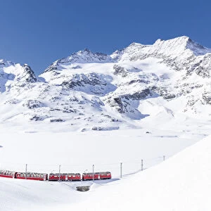 Bernina Express transit along Lago Bianco in winter, Bernina Pass, Engadin