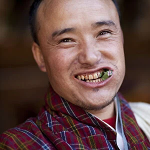 A Bhutanese man in a Gho eating Betel nut in Bhutan