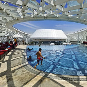 A boy jumps into the swimming pool of the Yas Marina Circuit Formula 1 race track
