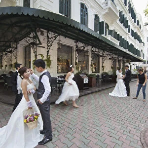 Brides and Grooms being photographed infront of the Sofitel Metropole Legend Hotel