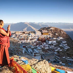 Buddhist monk praying in front of Ganden monastery, Tibet, China (MODEL RELEASED)