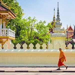 A buddhist monk walks past Wat Si Saket (Wat Sisaket) temple in central Vientiane, Laos