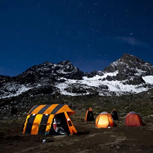 Camping under the full moon, night shot of Mount Kilimanajro with tents