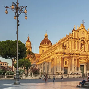 Catania, Sicily. People walking on the main square at sunset with the Cathedral in the