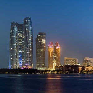 CIty skyline at twilight with Etihad Towers and Emirates Palace Hotel, Abu Dhabi