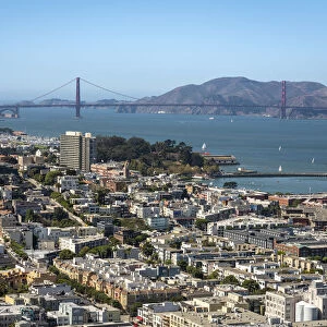 Cityscape near famous Golden Gate Bridge against blue sky on sunny day, San Francisco