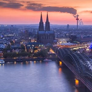 Cologne Cathedral and Hohenzoller Bridge over River Rhine in Cologne city at dusk