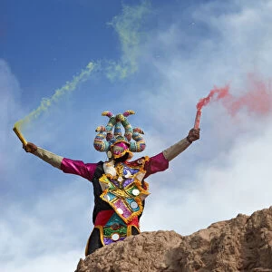 A devil mask of the Uquia's Carnival with bengala's during the "Descents of the Devil's", Jujuy, Argentina. Hundreds of devils descend from the "Cerro Blanco" hill to celebrate the start of Carnival