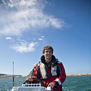 Dorset, England. Sailing coach Ian Martin prepares a course for the GBR 29ers sailing