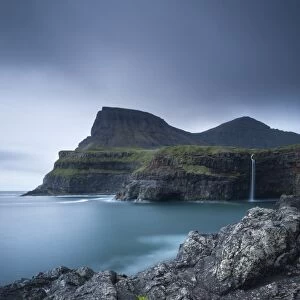 Dramatic coastline and waterfall at Gasadalur on the Island of Vagar, Faroe Islands
