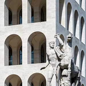 Equestrian sculpture with Palace of Italian Civilization (Palazzo della Civilta Italiana) behind, EUR district, Rome, Lazio, Italy