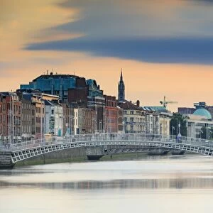Europe, Dublin, Ireland, Half Penny bridge at sunset reflecting in the Liffey river