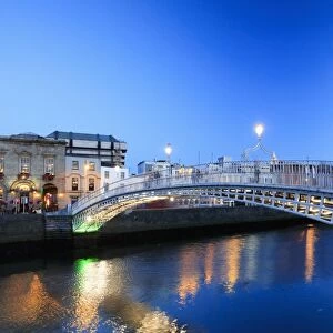 Europe, Dublin, Ireland, Halfpenny bridge by night reflecting on the Liffey river